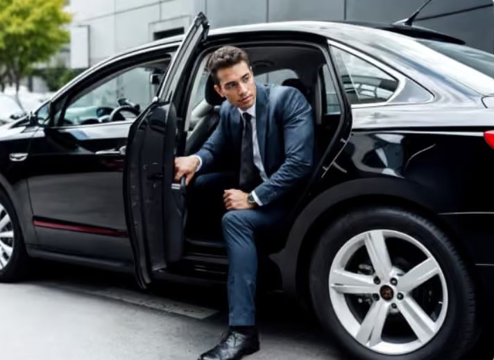 Business traveler stepping out of a black sedan
