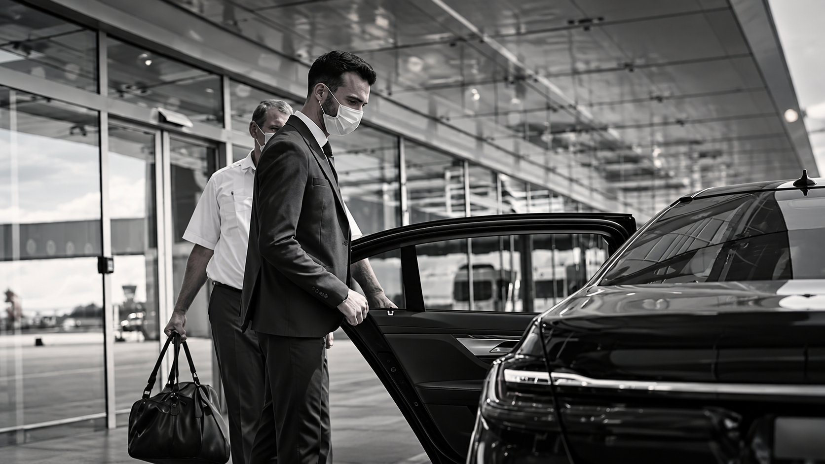 Chauffeur holding the car door for a passenger at the airport