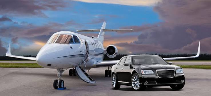 Black sedan parked beside a private jet on the tarmac